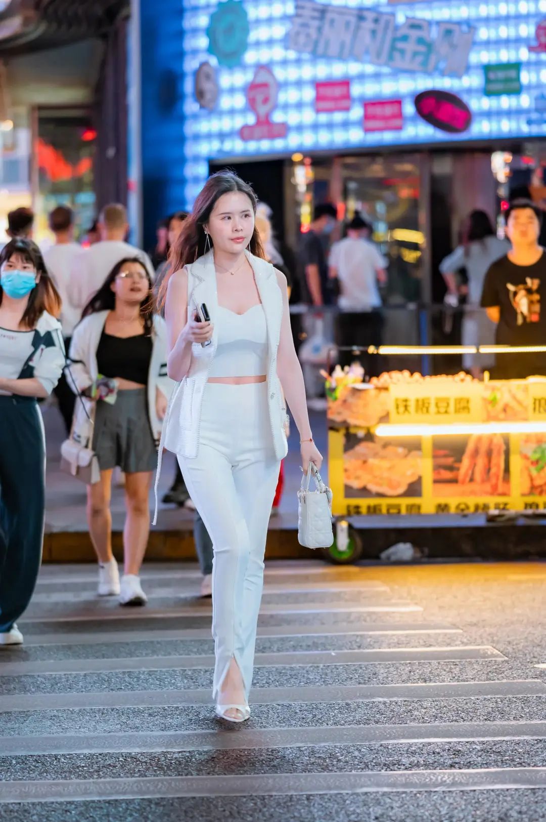 正在过马路的姐姐，白色的穿搭给人干净素雅的感觉，气质独特